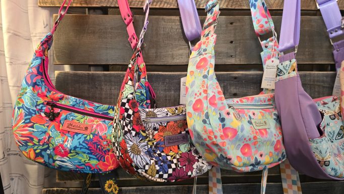 Colorful, patterned bags displayed on a wooden background.